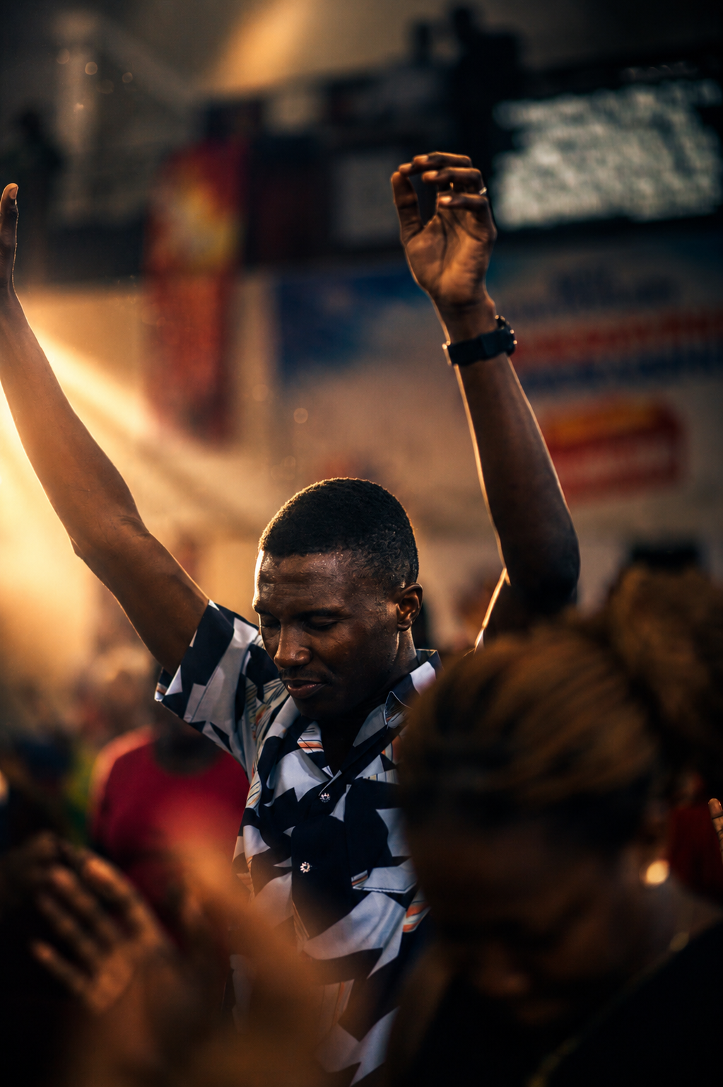 A worshipper with hands raised in praise during a service